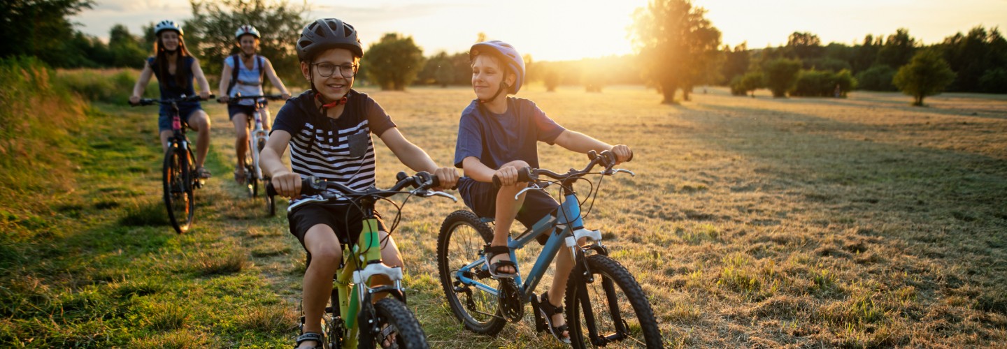 kids riding bikes through an empty field