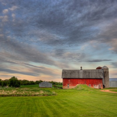 red barn beneath a cloudy sky