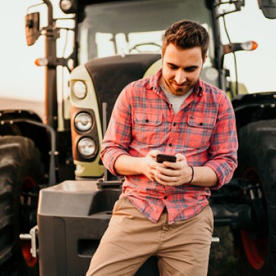 man in front of tractor on phone