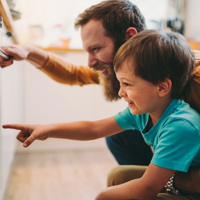 father and son looking into oven together